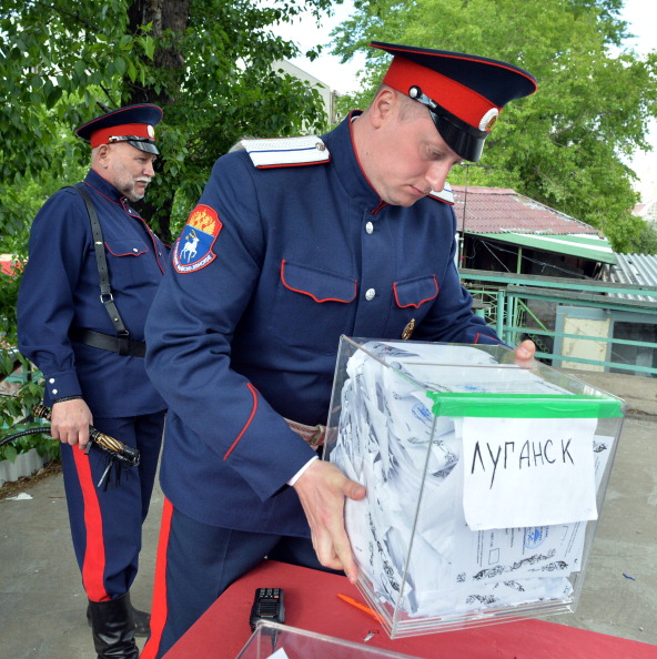 Русские казаки в военной форме в Москве несут урну, переданную с избирательного участка «референдума» для подсчёта голосов по Луганску 11 мая 2014 года. Фото: YURI KADOBNOV/AFP/Getty Images